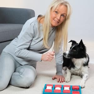 Nina Ottosson teaching her dog how to play with a dog puzzle.